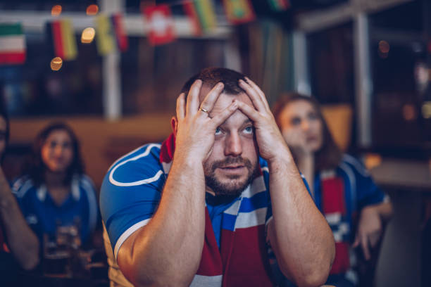 istock Disappointed man watching football game in bar 912755174