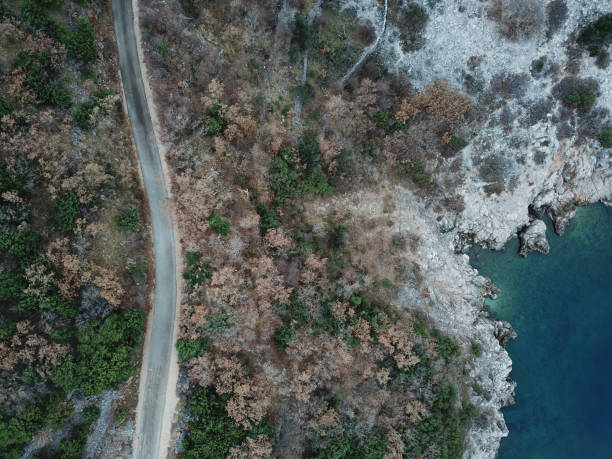 istock Single lane road by the sea from above 912755284