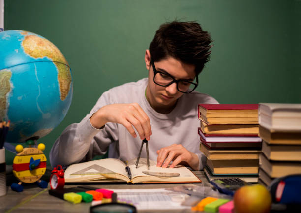 Education concept. Portrait of child with learning difficulties. Tired boy doing home assignment.