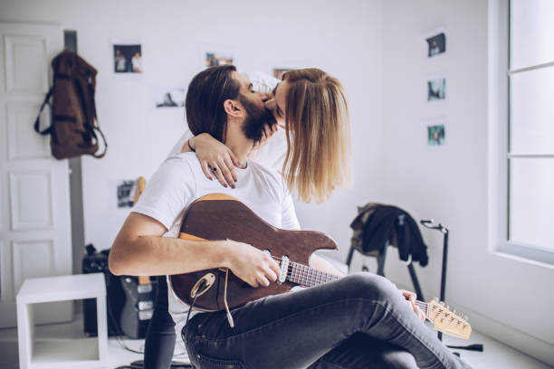 istock Lovely young couple playing guitar together 912760866
