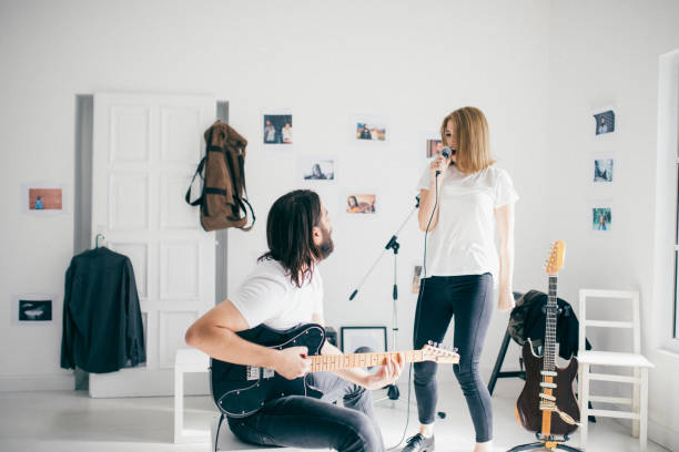 istock Happy couple singing and playing guitar together 912766316