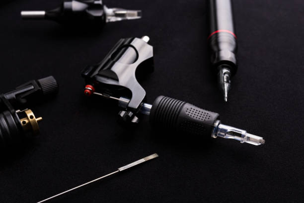 istock Tattoo machine and tattoo supplies on dark background 912766378