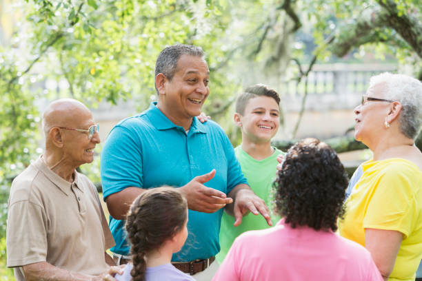 istock Mature Hispanic man talking with multi-generation family 912785464
