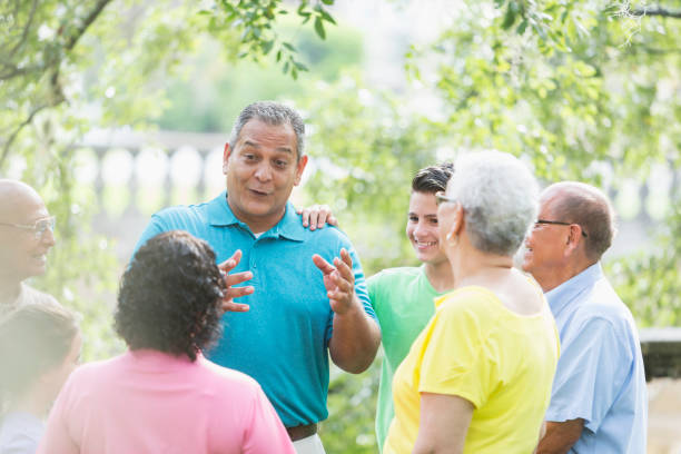 istock Mature Hispanic man talking with multi-generation family 912785472