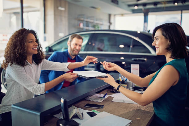Couple is buying new car and signing the contract stock photo