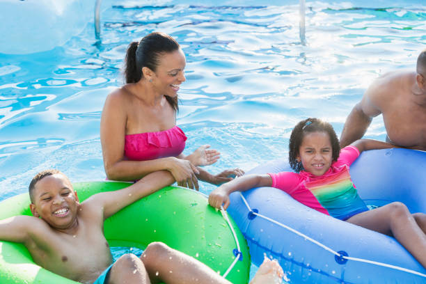 istock Mixed race family having fun in swimming pool 912785776