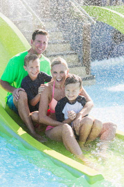 istock Family with two boys on waterslide at a water park 912785874