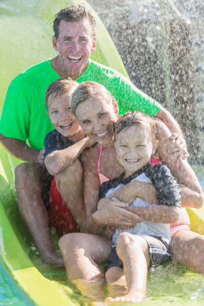 istock Family with two boys on waterslide at a water park 912785900