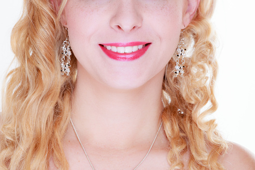 Beauty of smile concept. Woman wearing beautiful earrings smiling showing white teeth