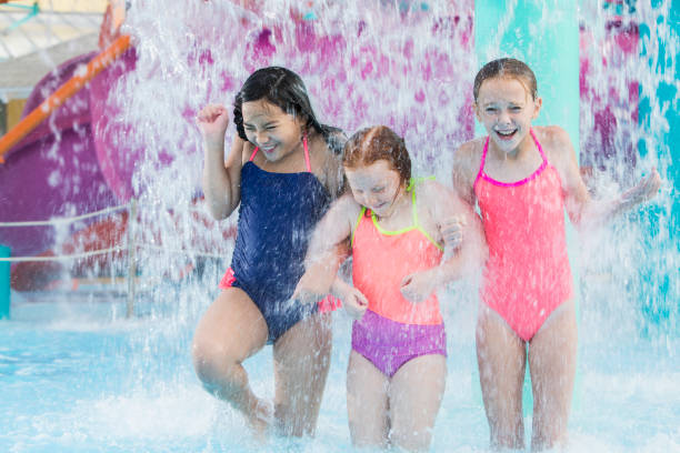 istock Three girls getting drenched at water park 912786398