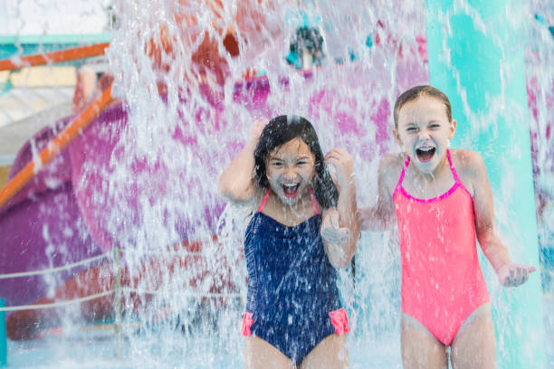 istock Two girls getting drenched at water park 912786434
