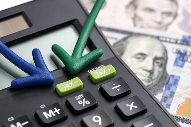 United States tax cuts, reform / reduce concept, arrows pointing to TAX minus button on calculator with background of blurred US Dollar banknotes, government offer tax deduction policy. estados unidos recortes, la reforma de impuestos / reducir a concepto, flechas apuntando al impuesto menos el botón de calculadora con el fondo de los billetes de dólar de los e.e.u.u. borrosa, política de deducción de impuesto de gobierno oferta