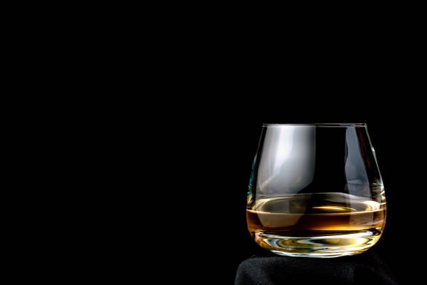 The glass of cognac or brandy isolated on a black background. Place for your text.