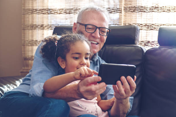 istock Grandfather playing with granddaughter on a mobile 912793078