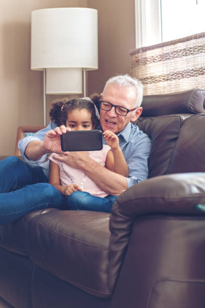 istock Grandfather playing with granddaughter on a mobile 912793080