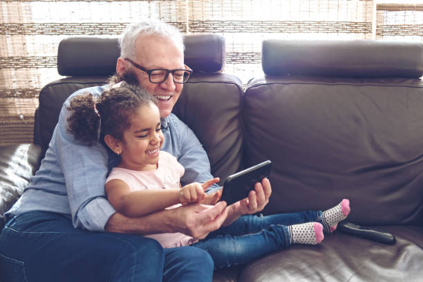 Grandfather playing with granddaughter on a mobile