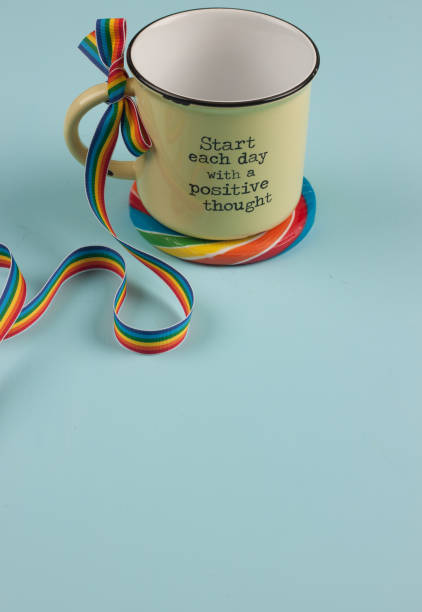 istock yellow mug on rainbow coaster and rainbow striped ribbon bow 912802608