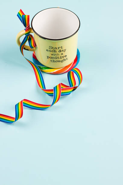 istock yellow mug on rainbow coaster and rainbow striped ribbon bow 912802612