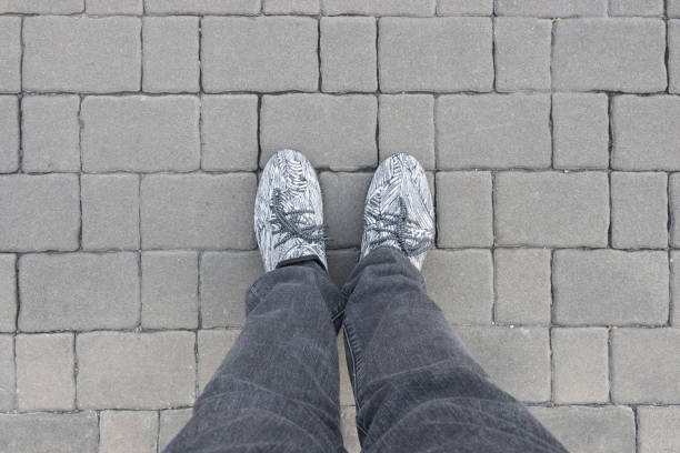 istock Gray brick blocks with man feet 912811796
