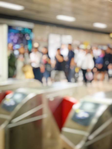 istock blurred image crowd of people standing and queue up at electronic ticket barriers for go out to work every morning in public transport subway station for background usage. Vintage tone. 912812012