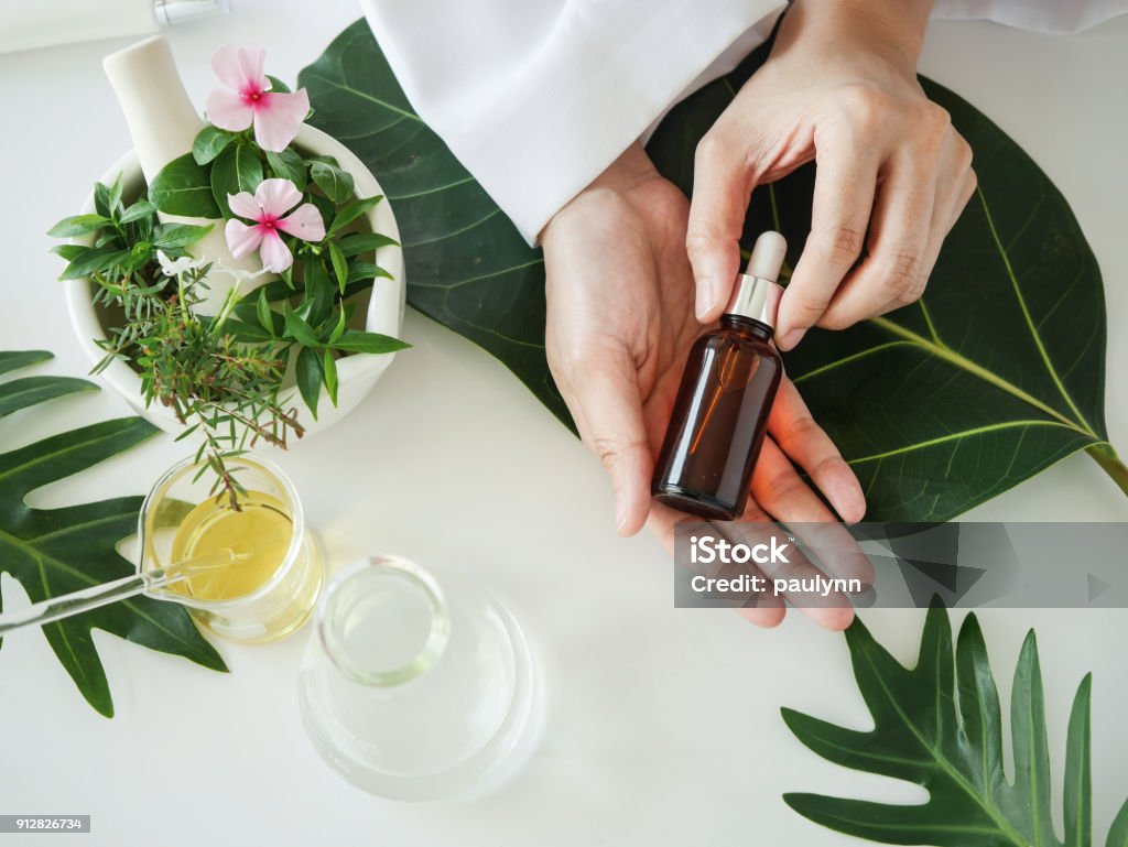 the scientist,dermatologist with the organic natural product in the laboratory.research and development beauty skincare concept.blank package,bottle,container .cream,serum.hand the scientist,dermatologist with the organic natural product in the laboratory.research and development beauty skincare concept.blank package,bottle,container .cream,serum.hand. Essential Oil Stock Photo