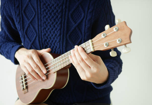 istock young asian playing ukulele. close up. hawaii instrument. 912827056