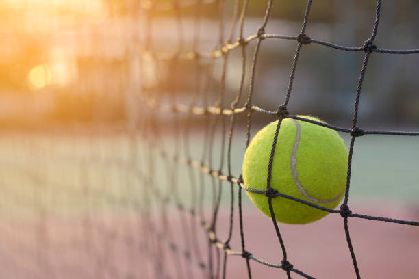 istock Close up Tennis ball hitting to net 912833296