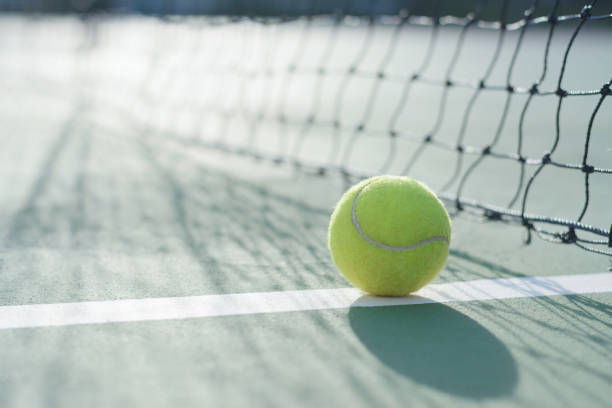 istock Tennis ball on blur net background 912833432