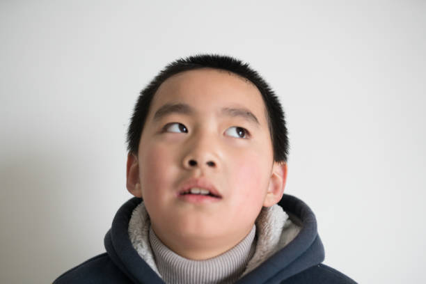 istock asian elementary age boy in home standing front of white wall 912833522
