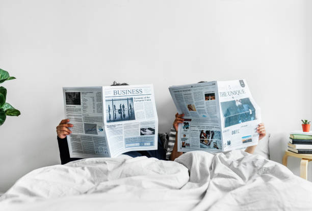 pareja asiática leyendo periódicos en la cama - newspaper reading blank women fotografías e imágenes de stock