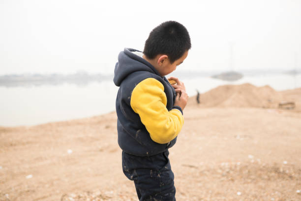 istock elementary age boy playing in the sand field next to the river 912837584