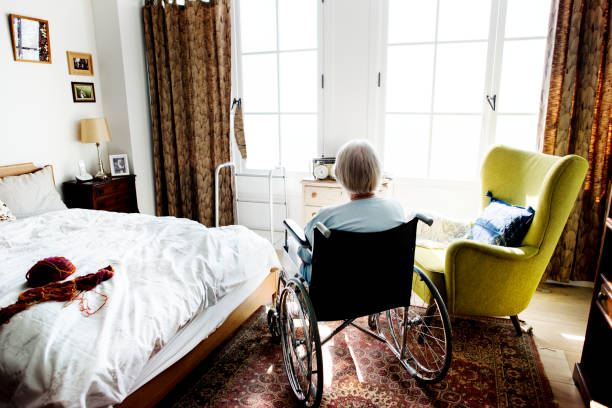 Senior woman sitting on the wheelchair alone Senior woman sitting on the wheelchair alone medical supplies wheelchair medical equipment nursing home stock pictures, royalty-free photos & images