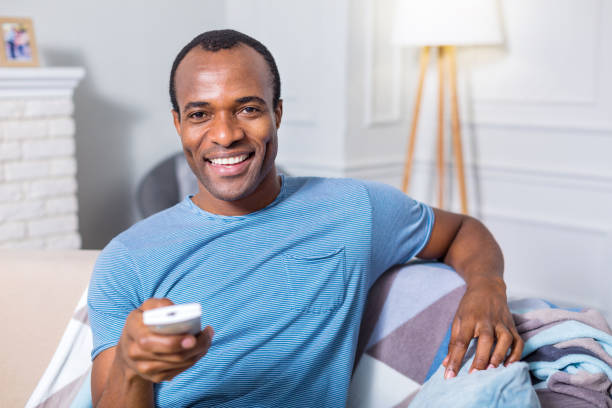 istock Happy nice man sitting in front of the TV screen 912854288