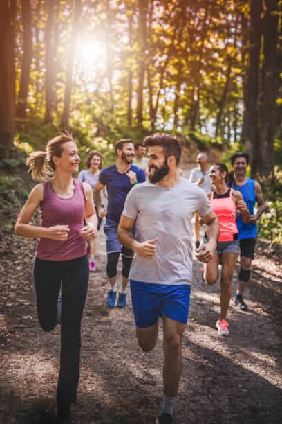 istock Happy marathon runners communicating during a race through forest. 912854432