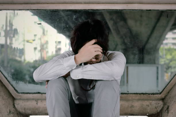 istock Anxious frustrated young Asian business man sitting and touching forehead with hands. 912858262