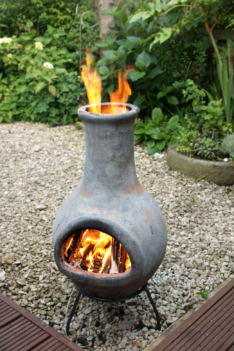 Chimnea burning wood to keep a patio warm