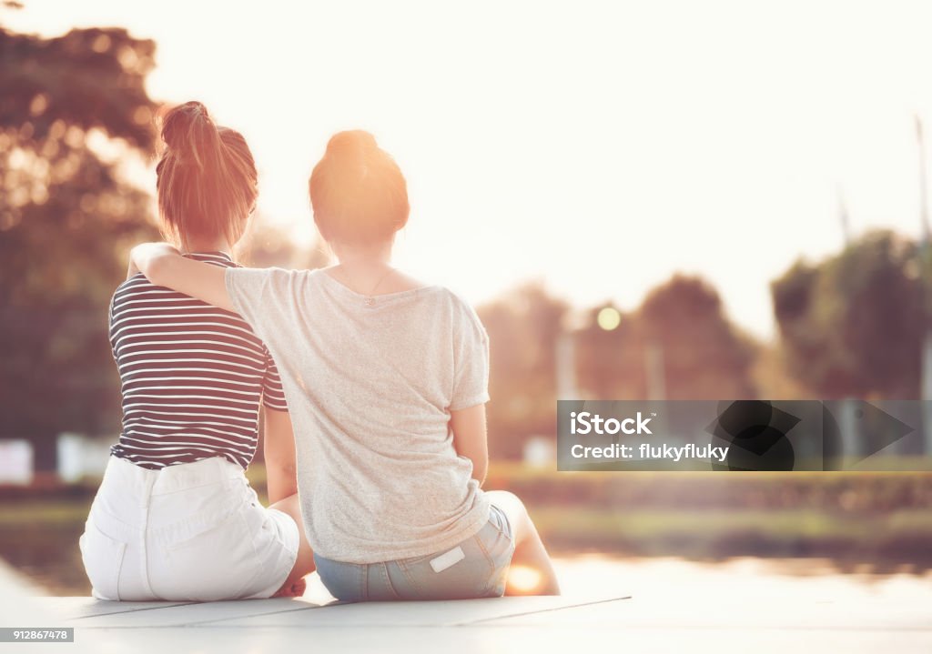 Zwei Freundinnen ruht im Garten, beobachten die Sonne zusammen glücklich. - Lizenzfrei Freundschaft Stock-Foto