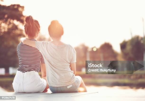 Due Amiche Che Riposano In Giardino Guardando Il Sole Insieme Felicemente - Fotografie stock e altre immagini di Amicizia