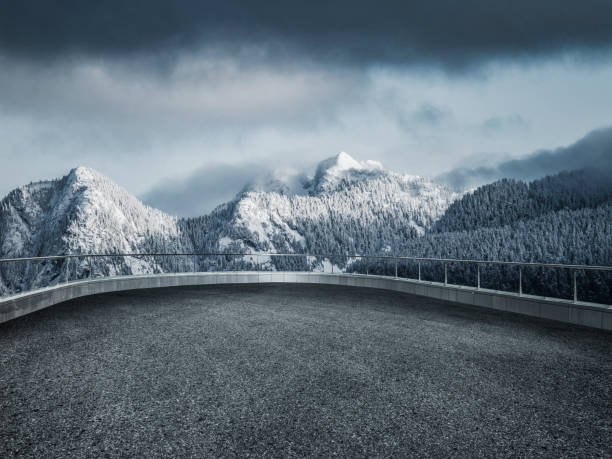 tortuosa strada innevata che porta verso montagne di neve - punto di osservazione foto e immagini stock