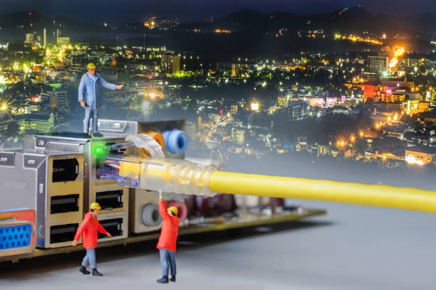 istock miniature engineer working on the motherboard of computer with network cable blending with city at night 912870746