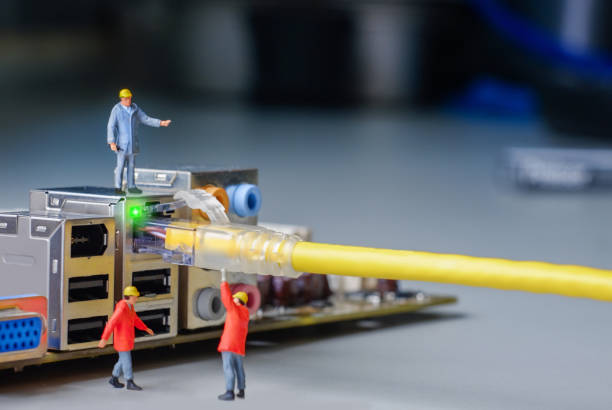 miniature engineer working on the motherboard of computer with network cable