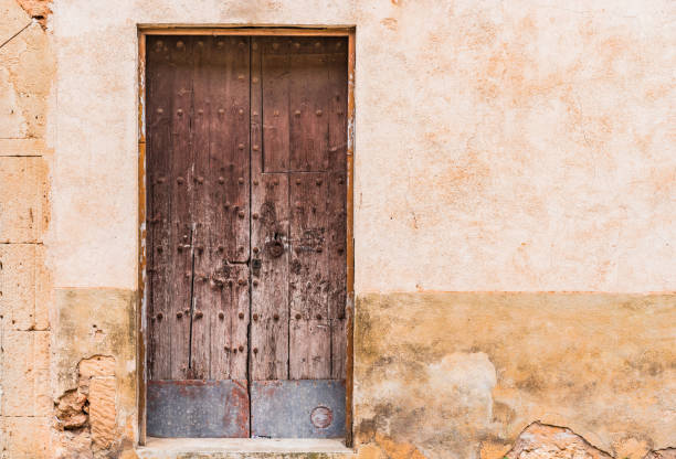 Age-old wooden front door and damaged wall background