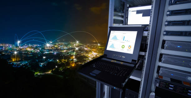smart city concept. monitor show graph information of network traffic and status of device in the server room of the data center and blending with cityscape panorama of Phuket city, Thailand at night stock photo