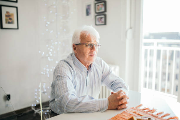 istock Senior man sitting by the window 912875428