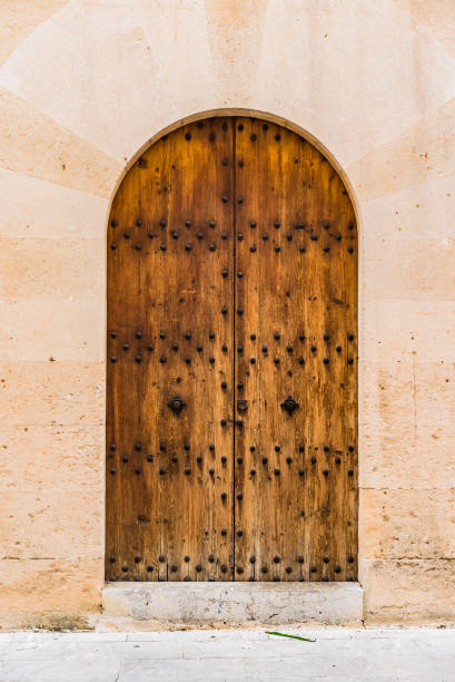 istock Ancient wooden door with stone arch, close-up 912876216