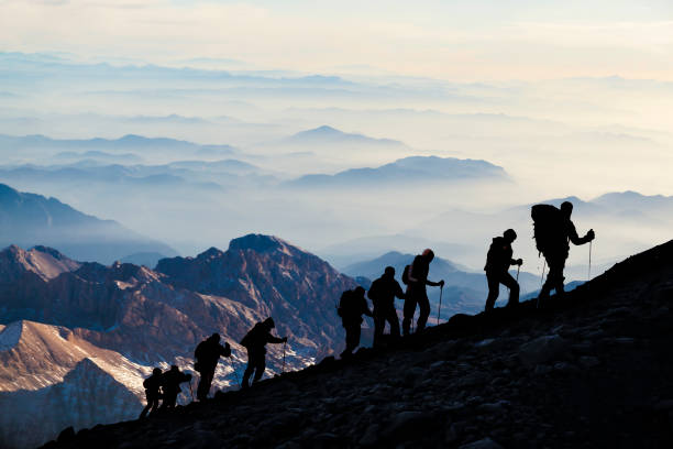 silhouettes of hikers at dusk - equipa desportiva imagens e fotografias de stock