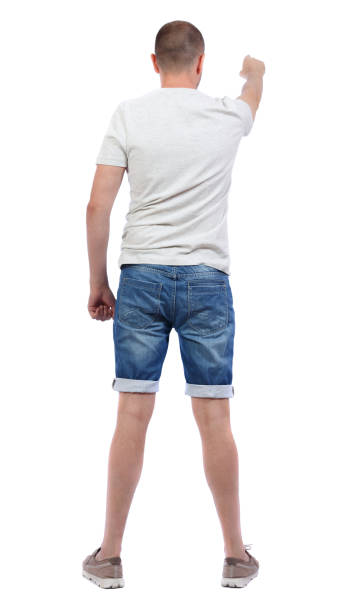 istock Back view of  pointing young men in  shirt and jeans. 912894190