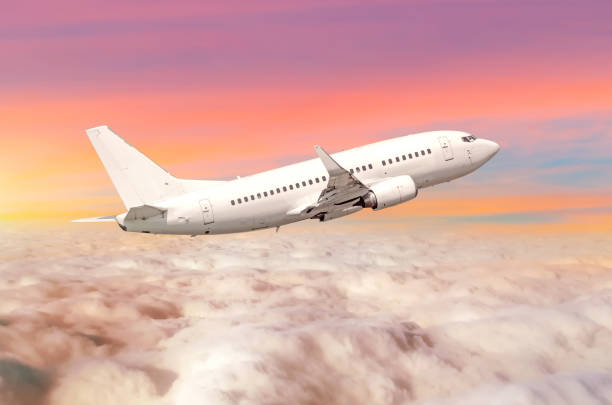 istock Flying airplane above the clouds horizon sky with bright sunset colors. 912894200