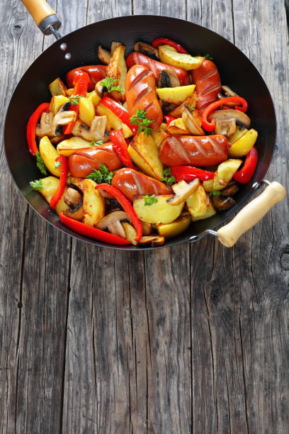 istock juicy grilled sausages with fried vegetables 912894462