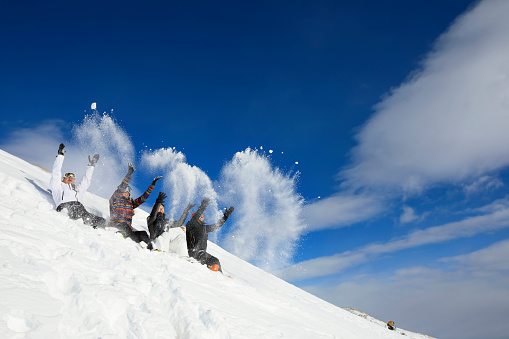Amateur Winter Sports  Group of skiers. Best friends men and women, snow skiers  playing Snowball fight on sunny ski resorts.  High mountain snowy landscape.  Italian Alps mountain of the Dolomites  Italy, Europe. Passo Tonale.